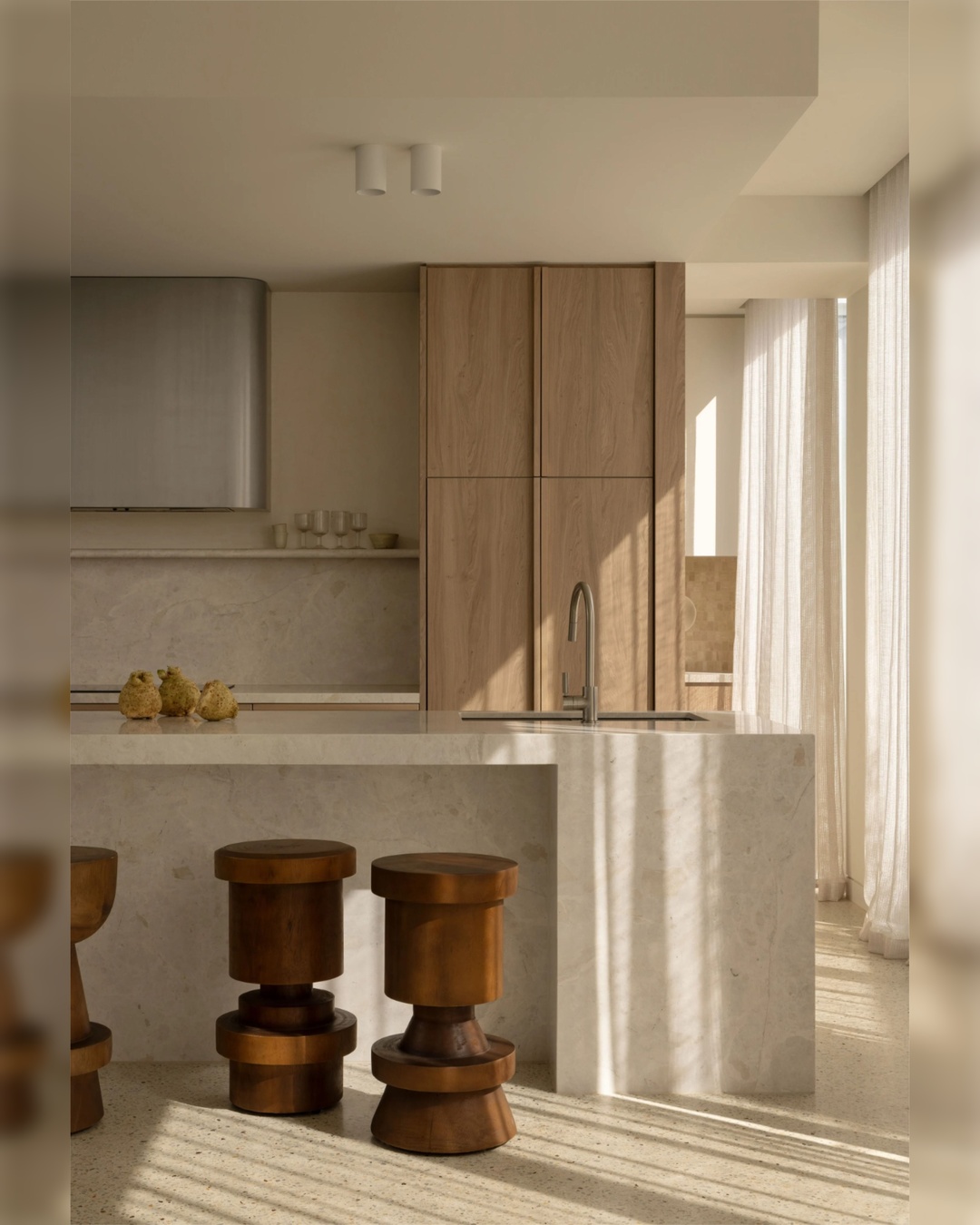 Neutral kitchen island with wood counter stools and stoneware canisters